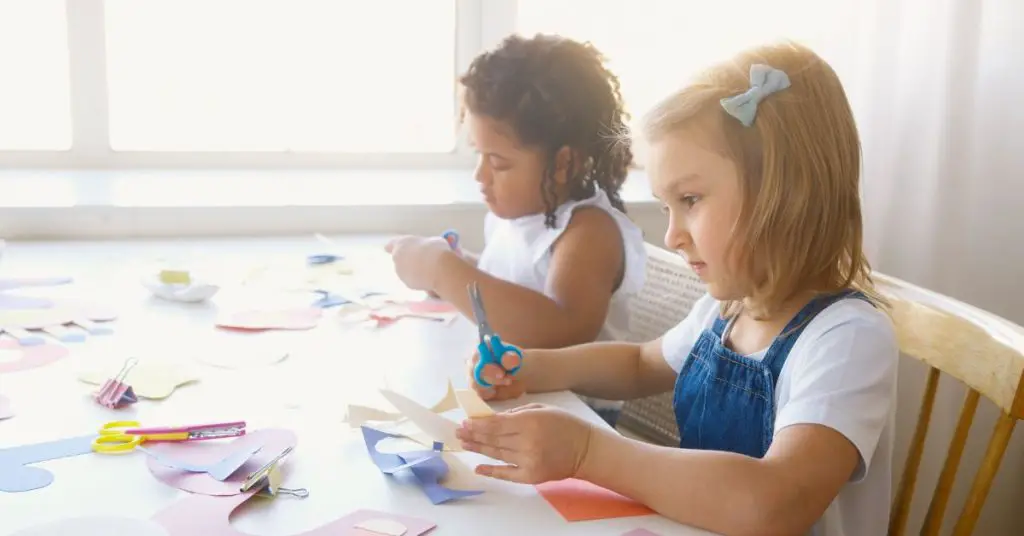 Girls cutting paper for craft