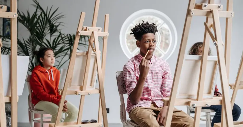 Students sitting in front of art easels